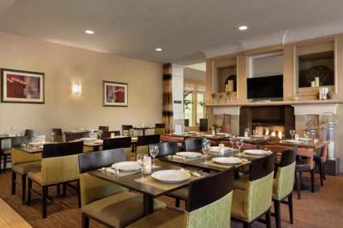 a restaurant with tables and chairs and a fireplace at Hilton Garden Inn Flagstaff in Flagstaff