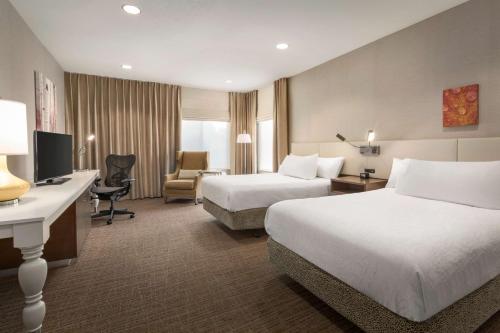 Habitación de hotel con 2 camas y escritorio en Hilton Garden Inn Flagstaff, en Flagstaff