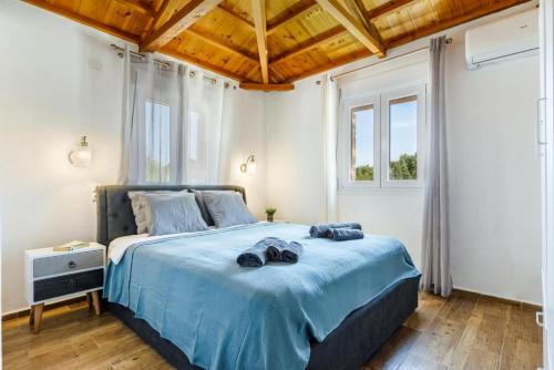 - une chambre dotée d'un grand lit avec des draps bleus dans l'établissement Oak Tree Cottage, à Pefkias