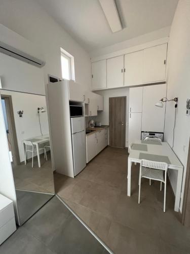 a kitchen with a table and a white refrigerator at Pap köz apartman in Sárvár