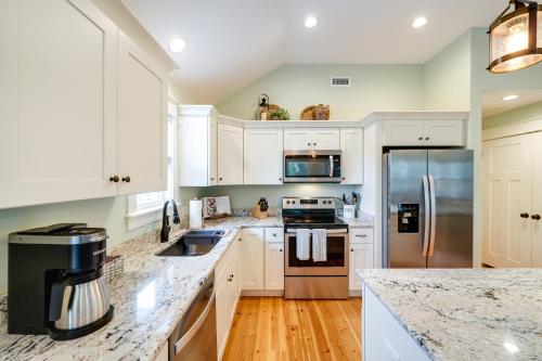 a kitchen with white cabinets and stainless steel appliances at Kill Devil Hills Retreat with Gas Grill and Deck! in Kill Devil Hills