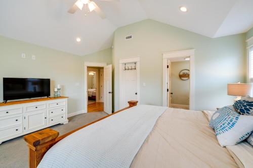 a large bedroom with a large bed and a flat screen tv at Kill Devil Hills Retreat with Gas Grill and Deck! in Kill Devil Hills