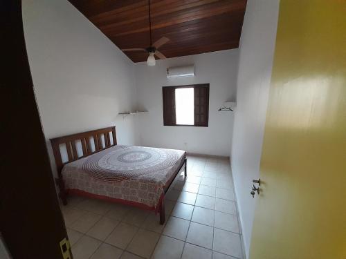 - une chambre avec un lit et une fenêtre dans l'établissement Mandala casa 3 dorms cond fech piscina churrasqueira, à Boicucanga