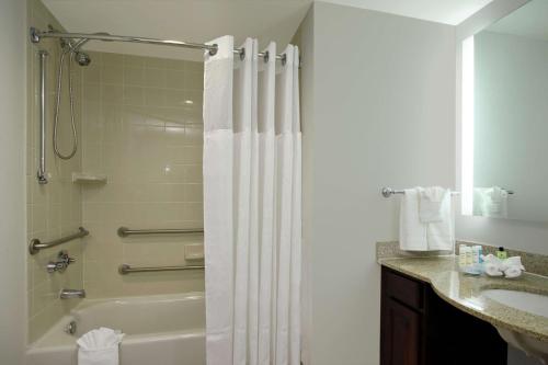 La salle de bains est pourvue d'un rideau de douche et d'un lavabo. dans l'établissement Homewood Suites by Hilton Fort Lauderdale Airport-Cruise Port, à Dania Beach