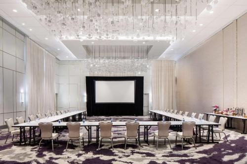 a conference room with a table and chairs and a screen at Hilton Miami Aventura in Aventura