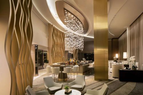 a restaurant with white chairs and tables and a chandelier at Hilton Miami Aventura in Aventura