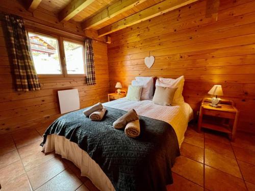 ein Schlafzimmer mit einem Bett in einem Blockhaus in der Unterkunft Chalet Baudelaire, 4* beau et authentique in Xonrupt-Longemer