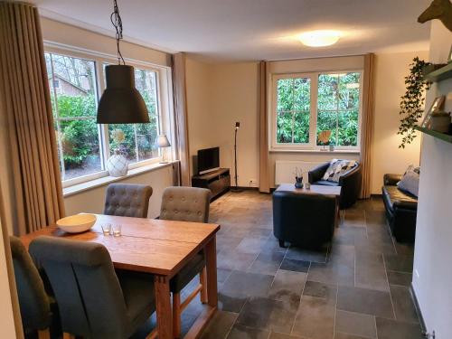 a living room with a table and a couch at Bungalowpark Bij de Bronnen in Nutter