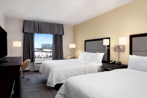 a hotel room with two beds and a window at Hampton Inn Hallandale Beach-Aventura in Hollywood
