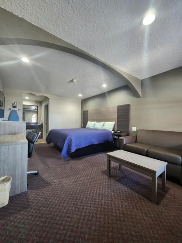 pokój hotelowy z łóżkiem i kanapą w obiekcie Scottish Inn and Suites Beaumont w mieście Beaumont