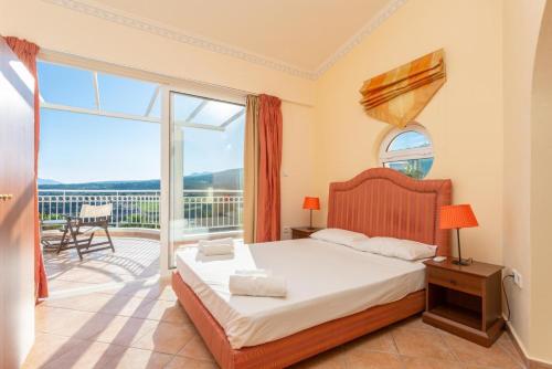 a bedroom with a bed and a balcony at Villa Asimenia in Agia Triada