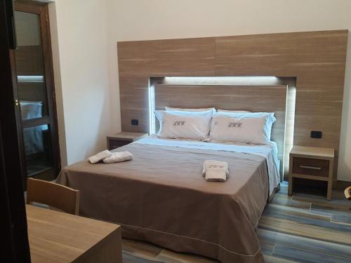 ein Schlafzimmer mit einem großen Bett mit zwei Handtüchern darauf in der Unterkunft LUXURY HOLIDAY HOUSE in Diamante