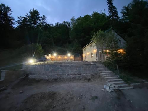 a stone house with lights in the dark at Villa Fresku in Peje