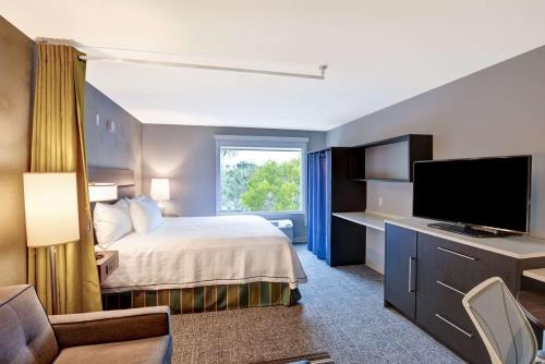 a hotel room with a bed and a flat screen tv at Home2 Suites by Hilton Miramar Ft. Lauderdale in Miramar