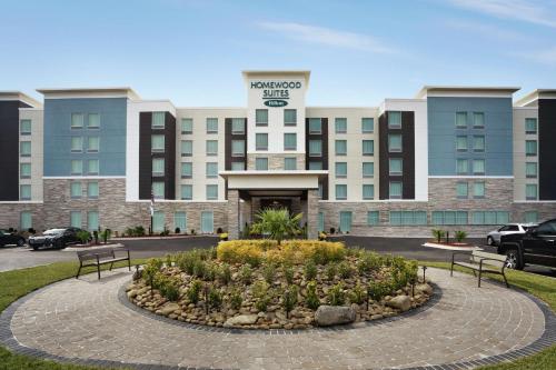 a hotel building with two benches in front of it at Homewood Suites By Hilton Florence in Florence