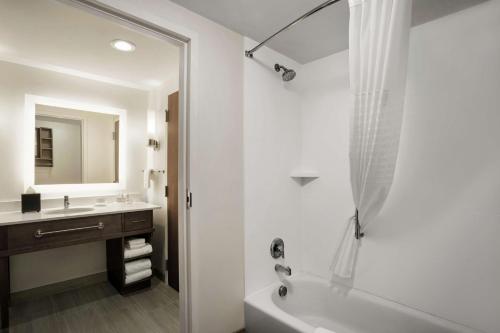 een witte badkamer met een bad en een wastafel bij Homewood Suites By Hilton Florence in Florence