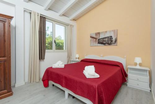 a bedroom with a red bed and a window at Villino Malva in Ragusa