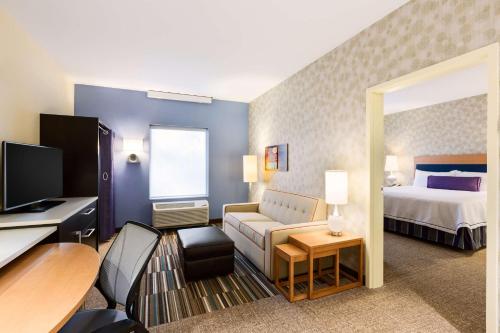 Habitación de hotel con cama y sala de estar. en Home2 Suites by Hilton Sioux Falls Sanford Medical Center en Sioux Falls
