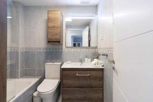 a bathroom with a toilet and a sink and a tub at Townhouse with 3 bedrooms and sea views from the roof terrace in Torremolinos