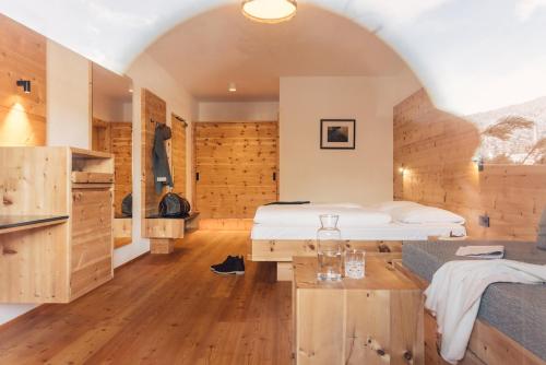 a bedroom with a bed and a table in a room at Hotel Restaurant Langgenhof in Brunico