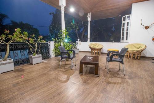 Habitación con suelo de madera, sillas y mesas. en Spacious 4BR 4BA Family Villa wt Balcony & Lavish Garden en Ratmalana