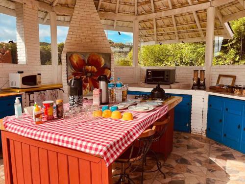 uma cozinha com uma mesa com uma toalha de mesa xadrez vermelha e branca em Cantinho de Campos em Campos do Jordão