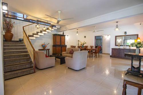 a living room with a staircase and a dining room at Spacious 4BR 4BA Family Villa wt Balcony & Lavish Garden in Ratmalana