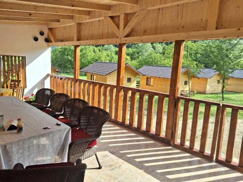 a patio with a table and chairs on a wooden deck at CAMPING THOBIAS in Alunu