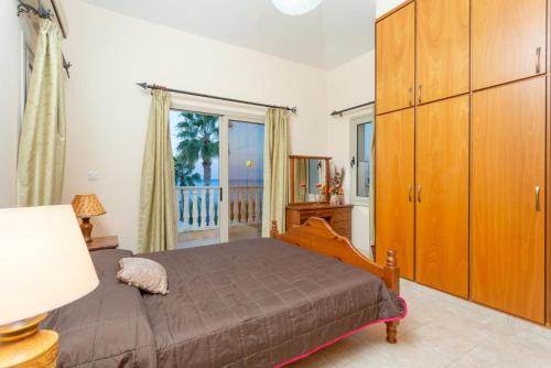 a bedroom with a bed and a dresser and a window at Villa Jan Lui in Argaka