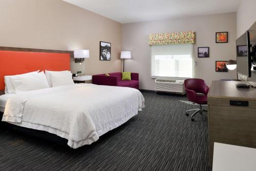 a hotel room with a large bed and a desk at Hampton Inn Fort Stockton in Fort Stockton