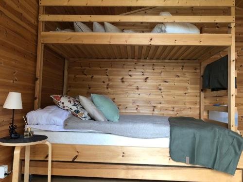a bunk bed in a room with a wooden wall at Stuga med sjöläge in Kopparberg