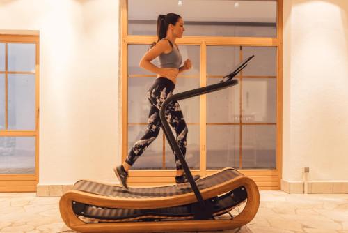 a woman is running on an exercise bike at Hotel Restaurant Langgenhof in Brunico