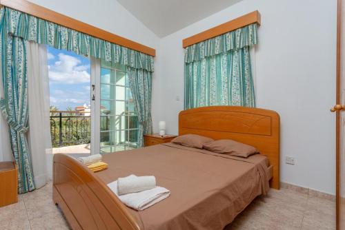 a bedroom with a bed and a large window at Villa Iliada in Polis Chrysochous