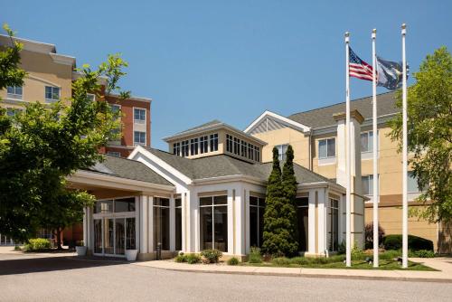 a building with an american flag in front of it at Hilton Garden Inn Fort Wayne in Fort Wayne