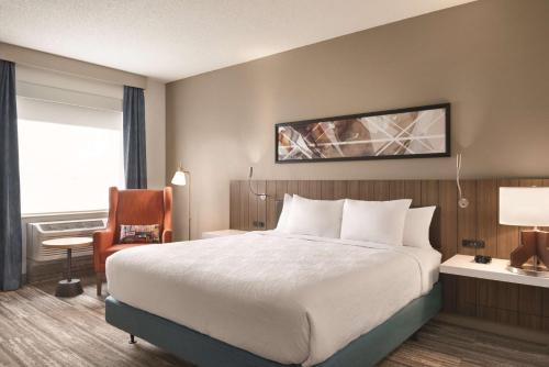a hotel room with a bed and a chair at Hilton Garden Inn Fort Wayne in Fort Wayne