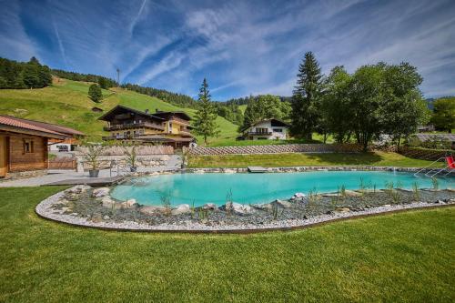 a swimming pool in the middle of a yard at Eibinghof BED & BREAKFAST in Saalbach-Hinterglemm
