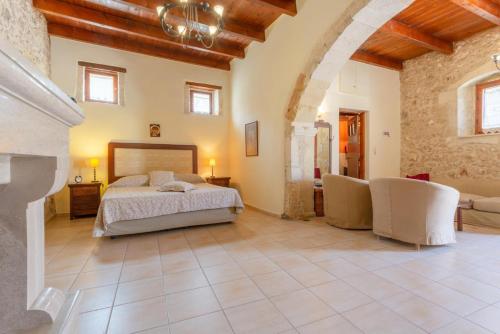 a large bedroom with a bed and a stone wall at Archontiko Galliaki in Áyios Yeóryios