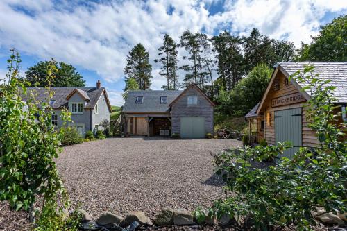 a driveway with a barn and a house at The Barn at Dormouse Cottage in Selkirk