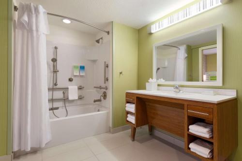 y baño con lavabo, bañera y ducha. en Home2 Suites By Hilton Gainesville en Gainesville