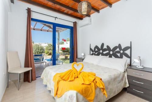 a bedroom with a bed with a yellow dress on it at Villa Tropical in Playa Blanca