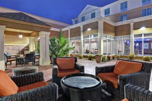 an outdoor patio with wicker chairs and tables at Hilton Garden Inn and Fayetteville Convention Center in Fayetteville