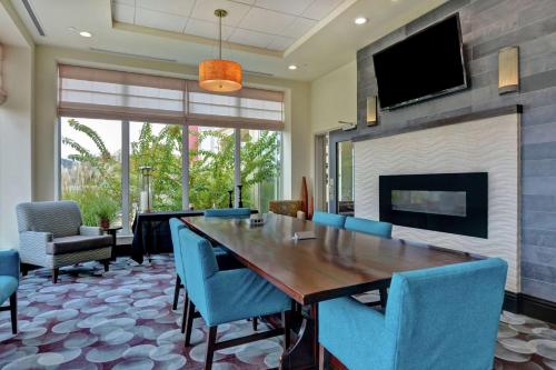 a dining room with a table and chairs and a fireplace at Hilton Garden Inn and Fayetteville Convention Center in Fayetteville