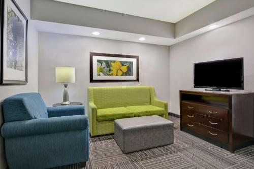 a living room with two chairs and a tv at Hilton Garden Inn and Fayetteville Convention Center in Fayetteville