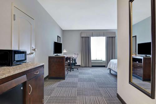 a hotel room with a bed and a mirror at Hilton Garden Inn and Fayetteville Convention Center in Fayetteville