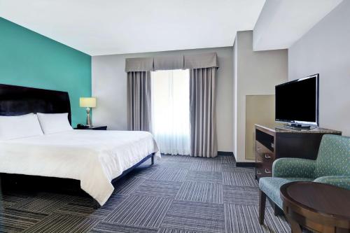 a hotel room with a bed and a flat screen tv at Hilton Garden Inn and Fayetteville Convention Center in Fayetteville