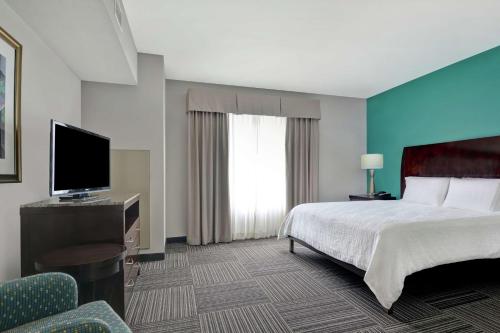 a hotel room with a bed and a flat screen tv at Hilton Garden Inn and Fayetteville Convention Center in Fayetteville