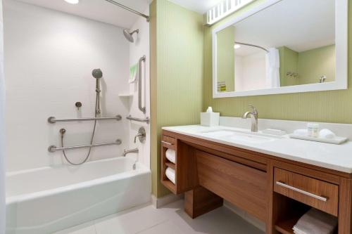 y baño con lavabo, bañera y espejo. en Home2 Suites by Hilton Gillette en Gillette