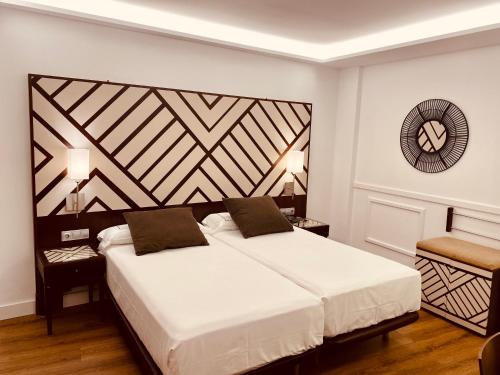 a bedroom with a large bed with a large headboard at Hotel Boutique Atrio in Valladolid