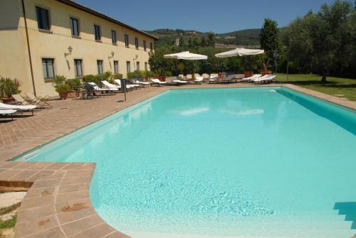 a large blue swimming pool next to a building at Relais dell'Olmo in Perugia