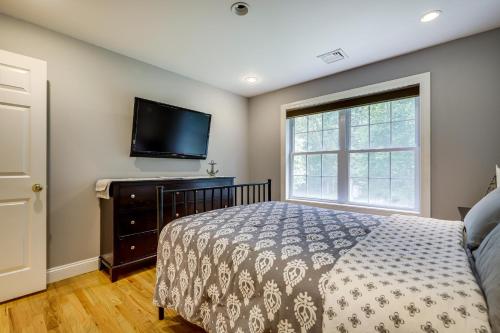 een slaapkamer met een bed en een flatscreen-tv bij Spacious Connecticut Home - Deck, Grill and Fire Pit in Mystic